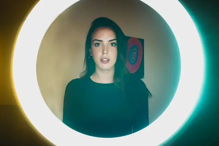 A creator framed by a ring light